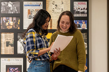 Two students talking. Links to Sylvia Wallace, Jour ’77 story